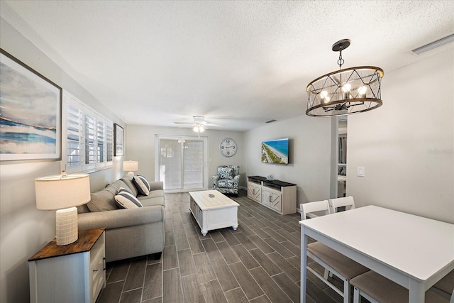 1123 Crescent St Unit 1123/1125, Sarasota, FL 34242 - living room featuring a chandelier, ceiling fan, a textured ceiling, and dark wood-style floors