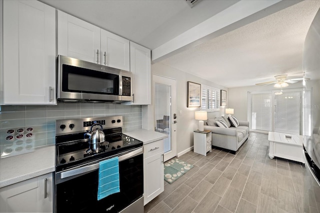 1123 Crescent St Unit 1123/1125, Sarasota, FL 34242 - kitchen featuring appliances with stainless steel finishes, tasteful backsplash, light countertops, open floor plan, and white cabinets