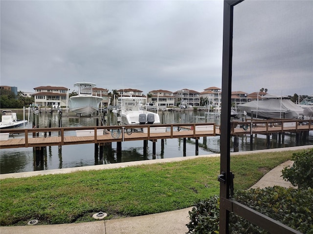 dock area with a water view and a yard