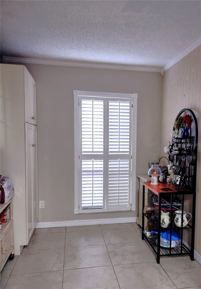 dining area featuring a textured ceiling, crown molding, and light tile patterned flooring