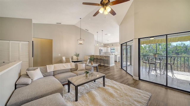 living room with ceiling fan, hardwood / wood-style floors, and high vaulted ceiling