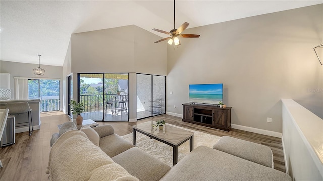 living room featuring hardwood / wood-style flooring, ceiling fan, and high vaulted ceiling