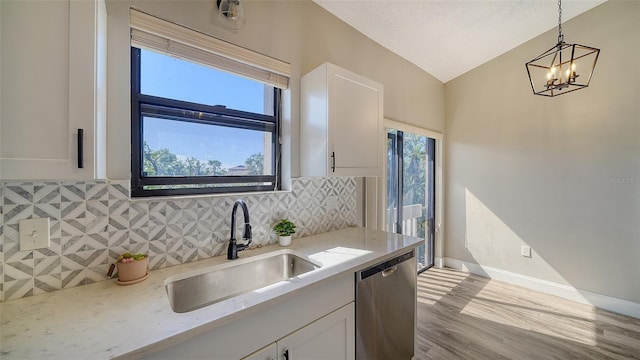 kitchen featuring hanging light fixtures, dishwasher, sink, and white cabinets