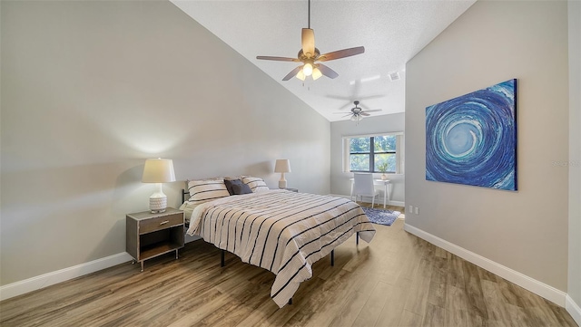 bedroom featuring hardwood / wood-style flooring, vaulted ceiling, a textured ceiling, and ceiling fan