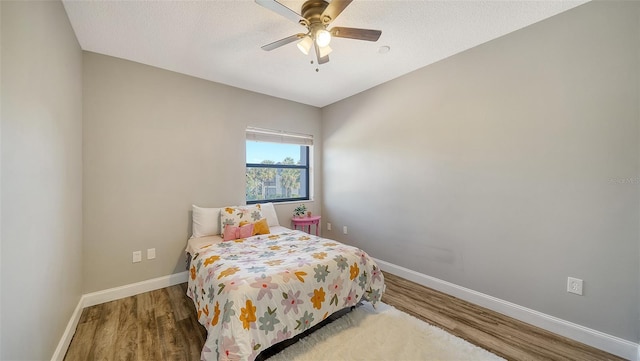 bedroom featuring hardwood / wood-style flooring, ceiling fan, and a textured ceiling