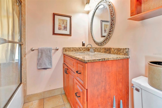 full bathroom featuring shower / bath combination with glass door, vanity, tile patterned flooring, and toilet