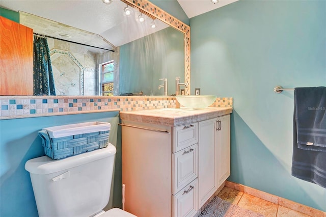 bathroom featuring vanity, toilet, and lofted ceiling