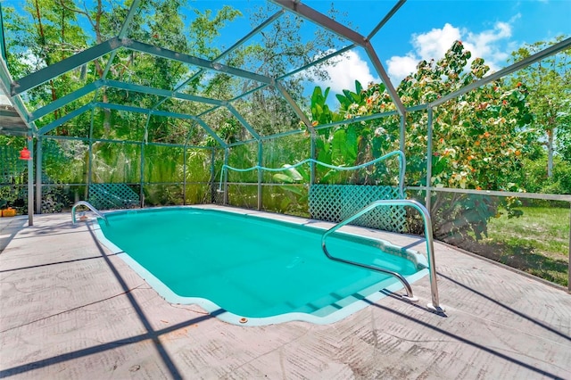 view of swimming pool featuring a patio area and glass enclosure