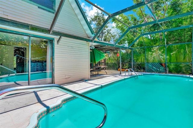 view of swimming pool with glass enclosure and a patio