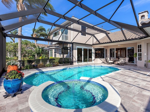 view of swimming pool featuring glass enclosure, a patio area, and an in ground hot tub