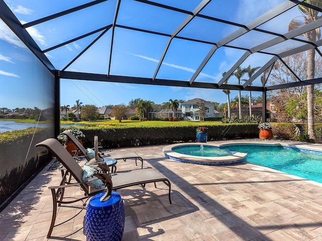 view of pool featuring glass enclosure, an in ground hot tub, a patio area, and a water view