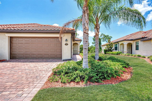 mediterranean / spanish house with a garage and a front lawn