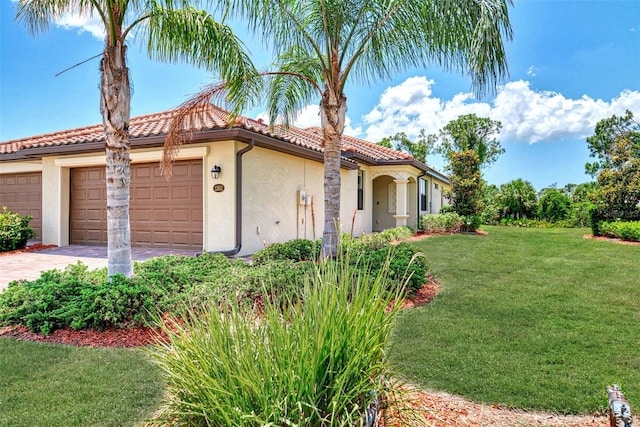 mediterranean / spanish-style house with a garage and a front lawn