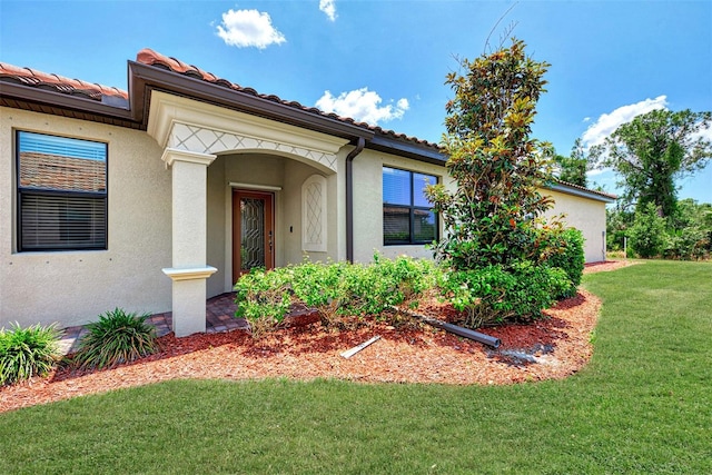 entrance to property featuring a yard