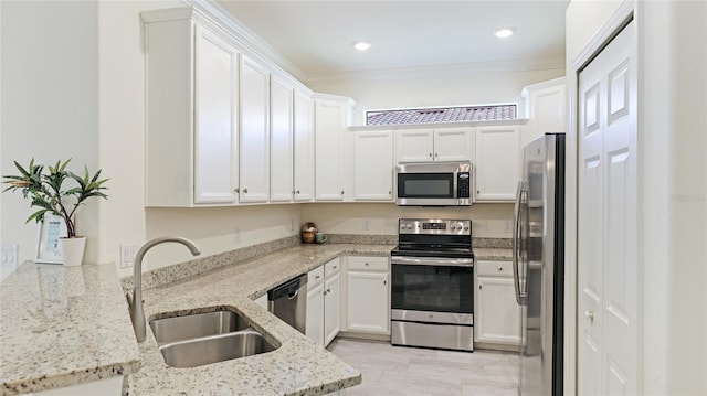 kitchen with sink, white cabinetry, kitchen peninsula, stainless steel appliances, and light stone countertops