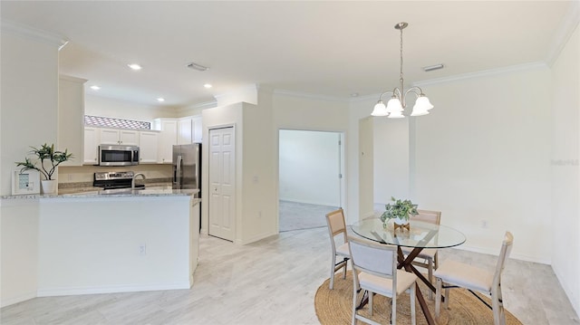 dining room featuring crown molding, light hardwood / wood-style floors, and an inviting chandelier