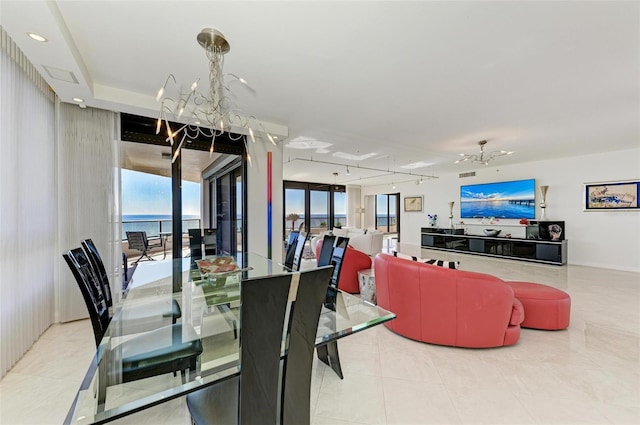 tiled dining space with a water view and a chandelier