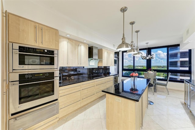 kitchen with a center island, stainless steel double oven, light brown cabinetry, and a chandelier