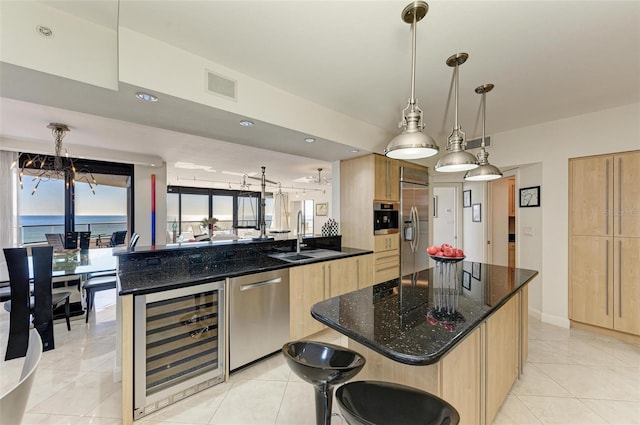 kitchen featuring a water view, sink, wine cooler, kitchen peninsula, and stainless steel appliances