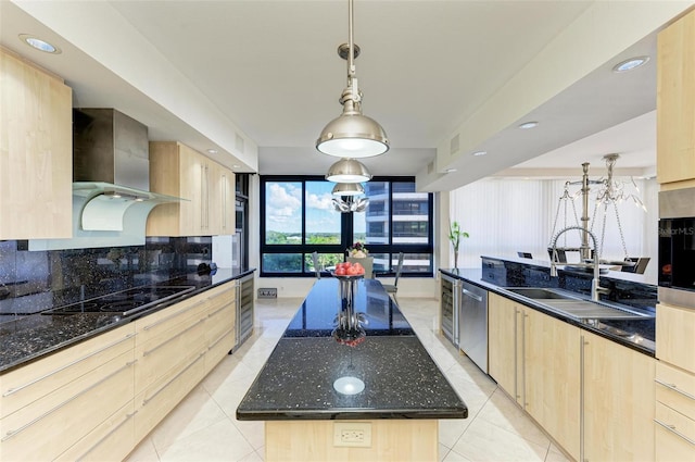 kitchen with black electric cooktop, a center island with sink, wall chimney exhaust hood, and light brown cabinetry