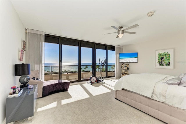 carpeted bedroom with multiple windows, access to exterior, a wall of windows, and ceiling fan