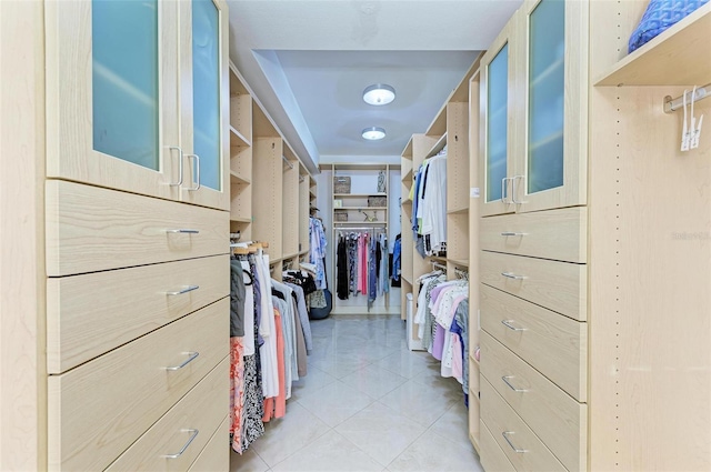 walk in closet with light tile patterned floors