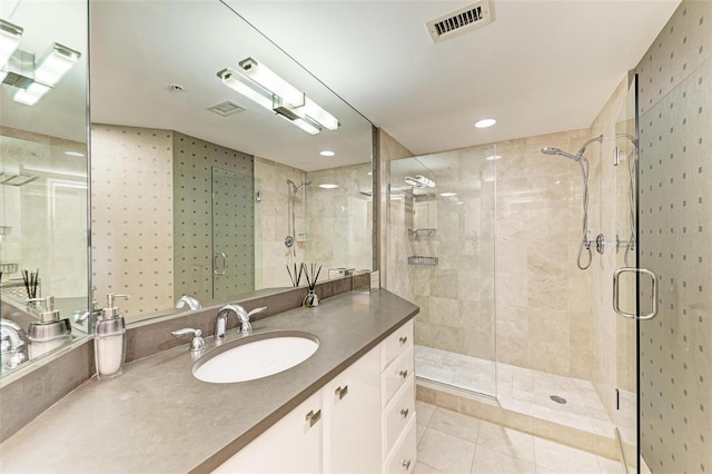 bathroom featuring vanity, tile patterned floors, and walk in shower