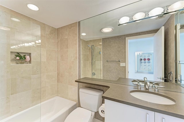 full bathroom with vanity, tiled shower / bath combo, and toilet