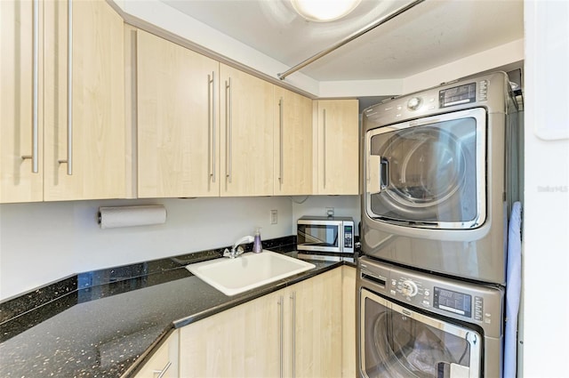 clothes washing area with stacked washer / drying machine and sink