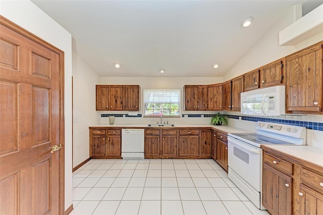 kitchen with lofted ceiling, white appliances, sink, light tile patterned floors, and tasteful backsplash