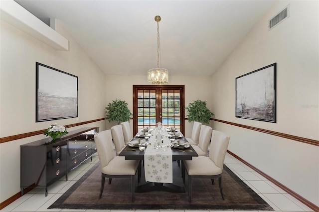 tiled dining space featuring a chandelier, vaulted ceiling, and french doors