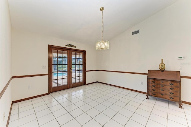 unfurnished room featuring a chandelier, vaulted ceiling, light tile patterned floors, and french doors