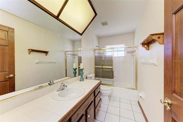 full bathroom featuring tile patterned floors, vanity, enclosed tub / shower combo, and toilet