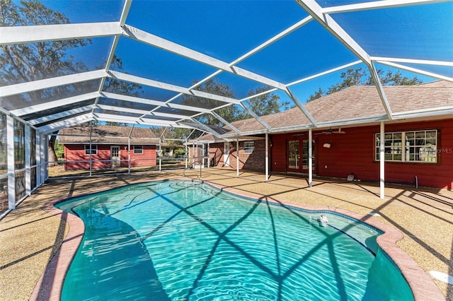 view of swimming pool featuring glass enclosure, ceiling fan, and a patio