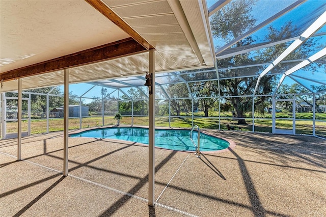 view of swimming pool featuring a lawn, glass enclosure, and a patio