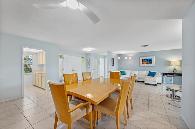 dining area with light tile patterned floors, visible vents, baseboards, ceiling fan, and a textured ceiling