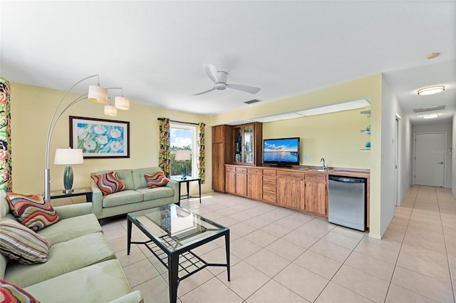 living room with a ceiling fan, indoor wet bar, visible vents, and light tile patterned floors