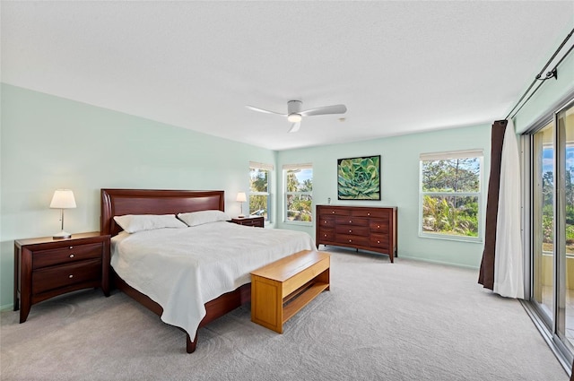 bedroom with access to exterior, a ceiling fan, and light colored carpet