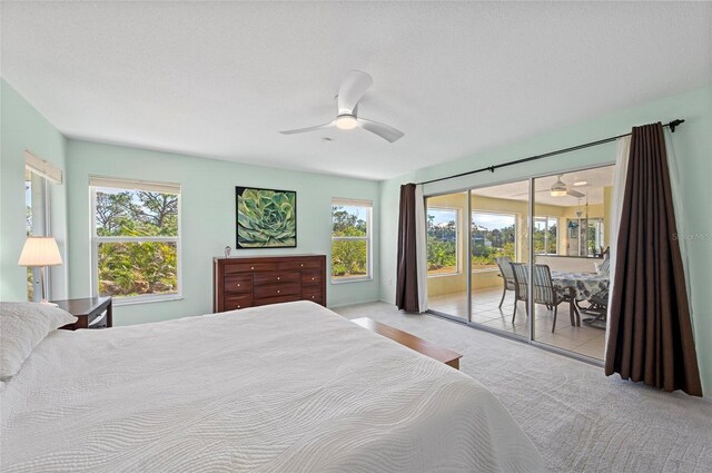 bedroom with light colored carpet, access to outside, multiple windows, and ceiling fan