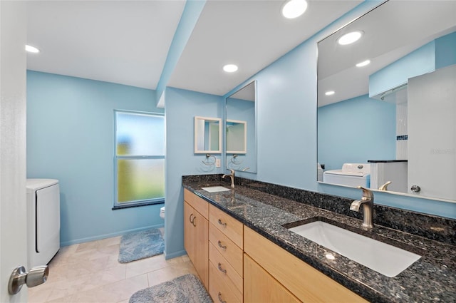 bathroom featuring toilet, double vanity, a sink, and recessed lighting