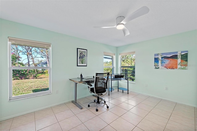 home office with ceiling fan, light tile patterned floors, a textured ceiling, and baseboards