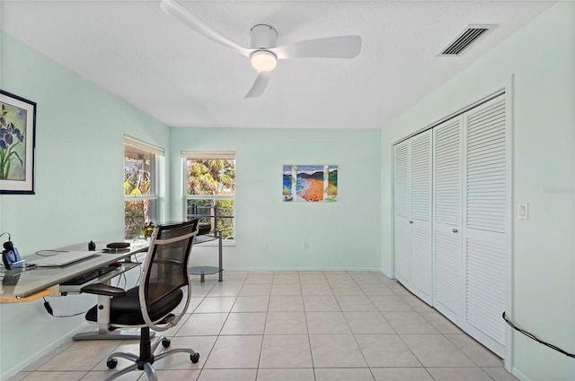 office area featuring a ceiling fan, visible vents, a textured ceiling, and light tile patterned floors