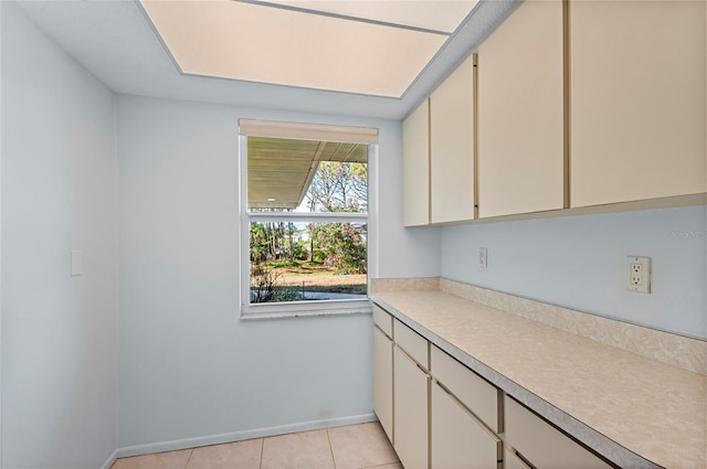 kitchen featuring light countertops, baseboards, and light tile patterned floors