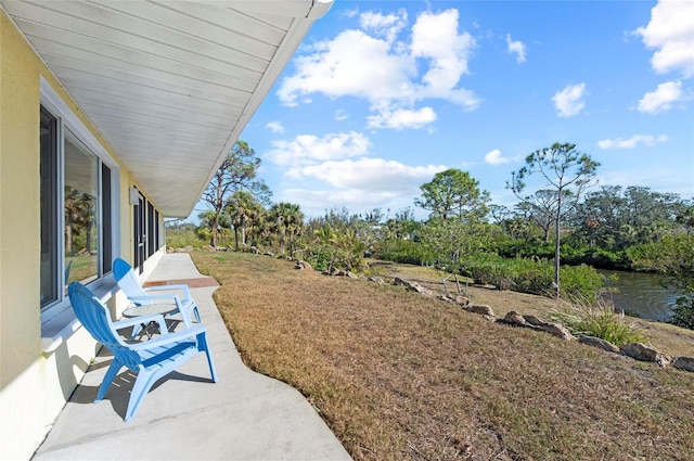 view of yard featuring a patio area and a water view