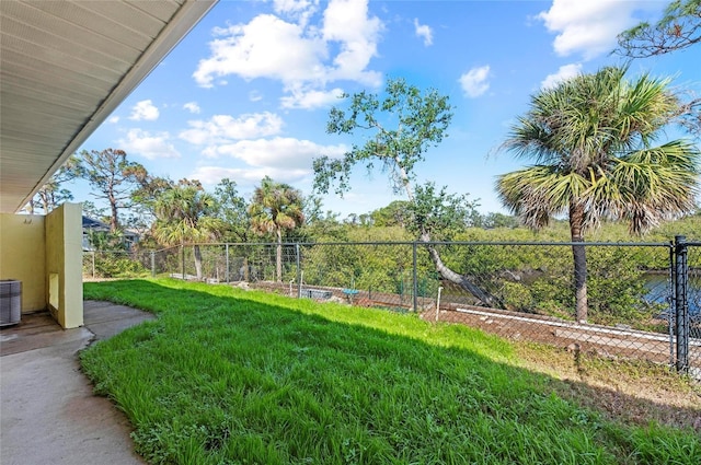 view of yard with central air condition unit and fence