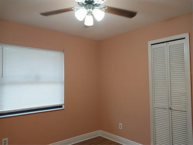 unfurnished bedroom featuring hardwood / wood-style floors, ceiling fan, and a closet