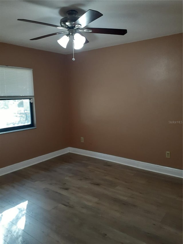 empty room with ceiling fan and dark hardwood / wood-style floors