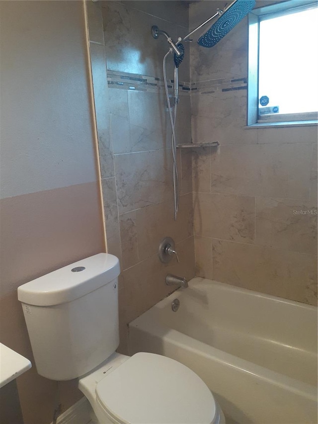 bathroom featuring toilet and tiled shower / bath