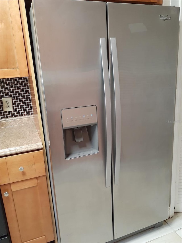 room details featuring tasteful backsplash and stainless steel fridge with ice dispenser