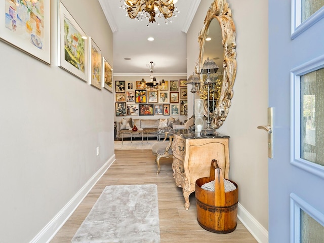 interior space featuring ornamental molding, a notable chandelier, and light hardwood / wood-style flooring